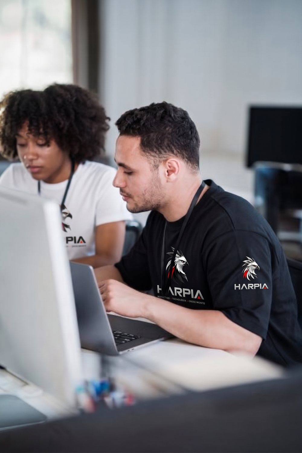 Dois integrantes do time trabalhando em computadores