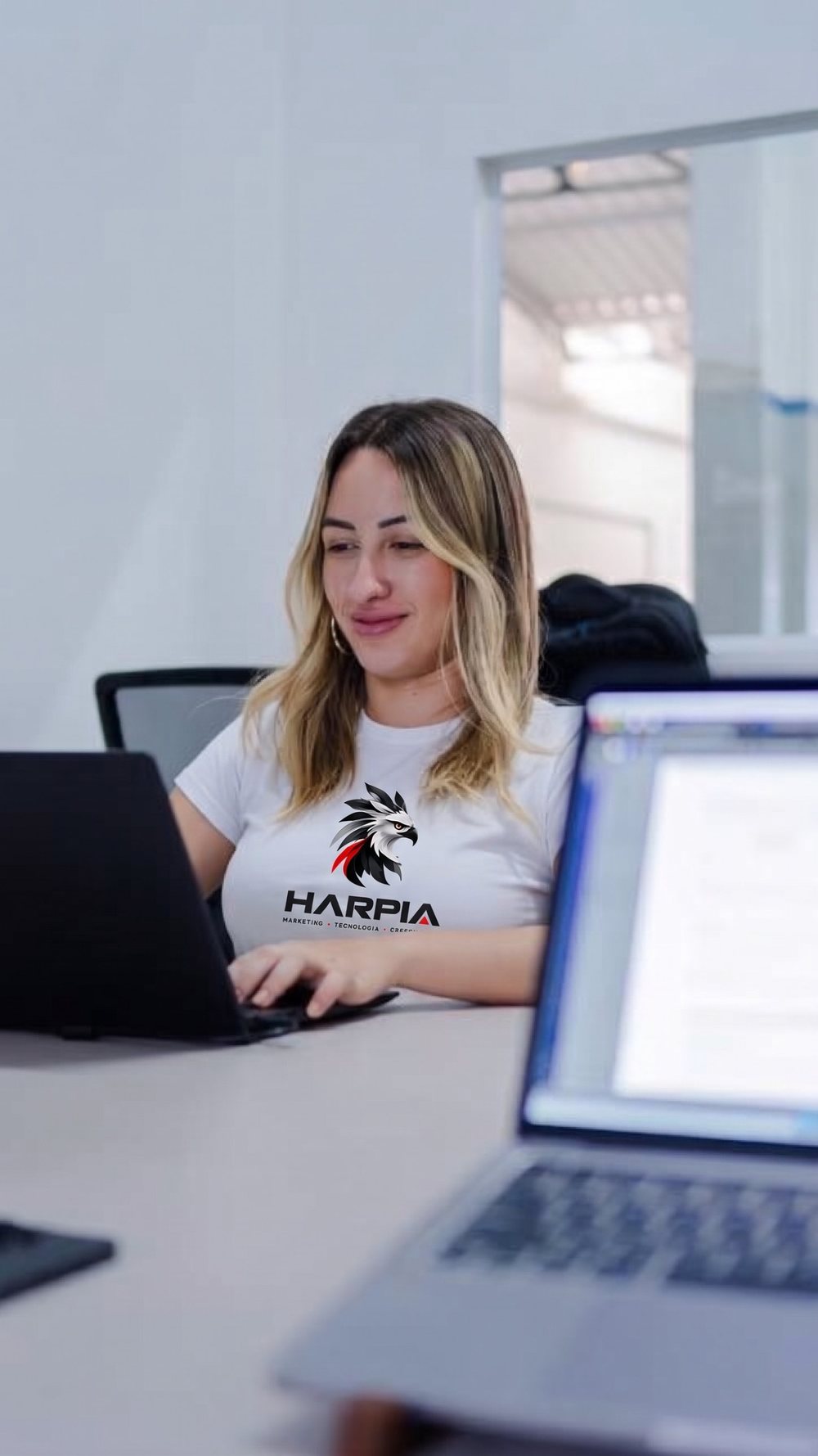 Integrante do time sorrindo diante do notebook