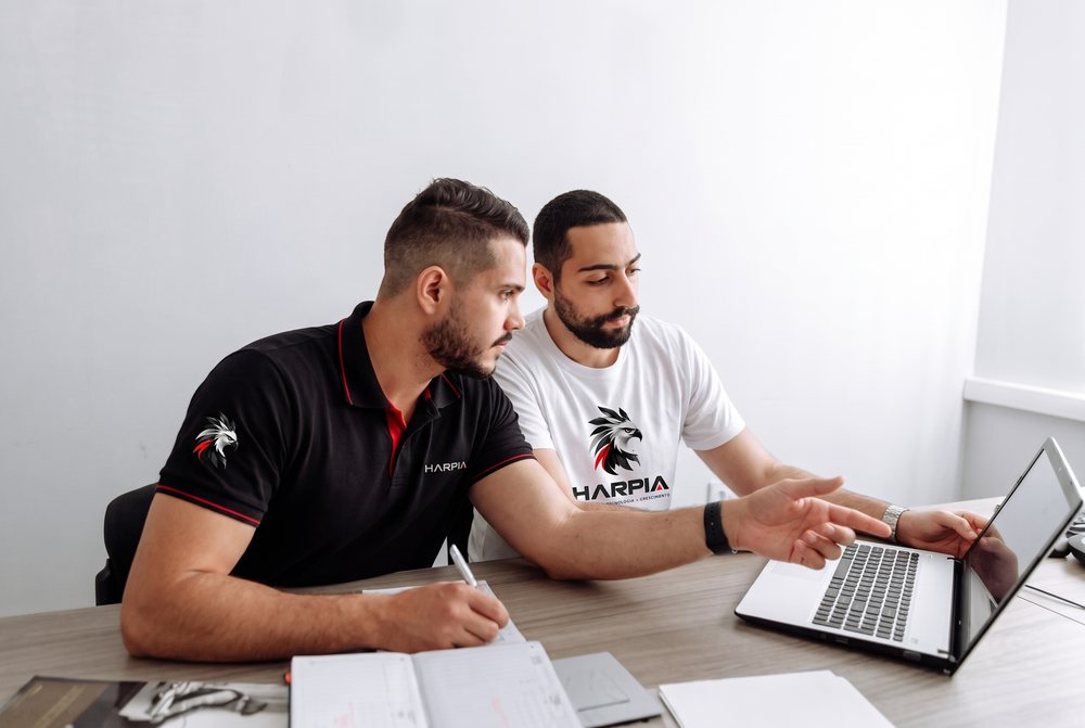 Dois integrantes do time discutindo uma tela de notebook