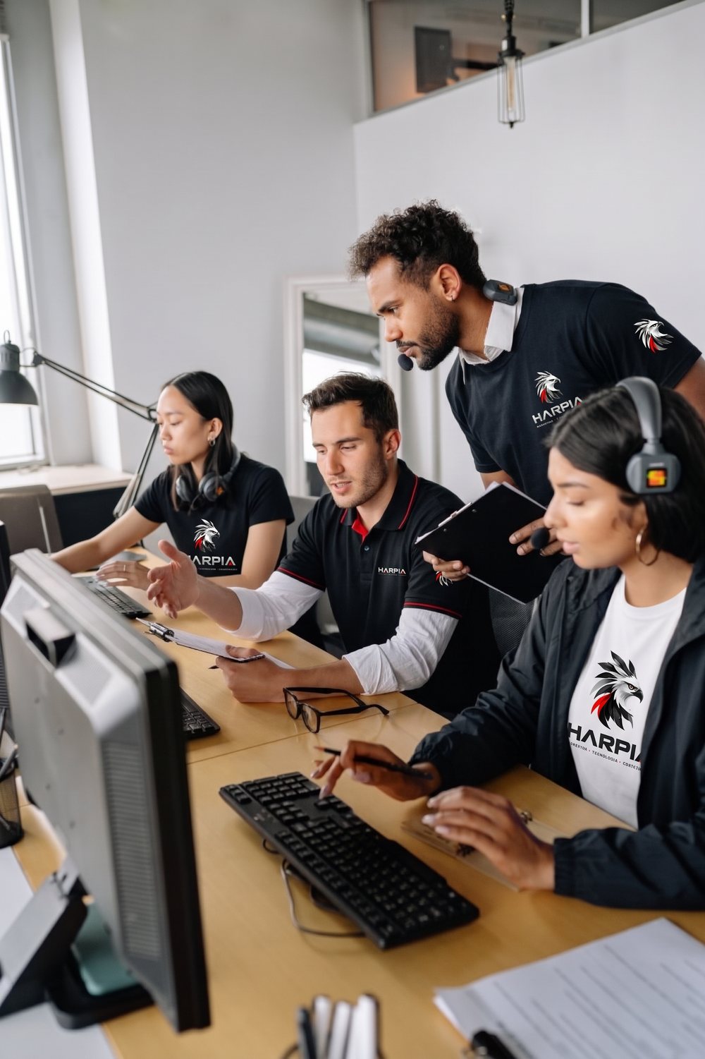 Quatro integrantes do time em uma operação com computadores e fones